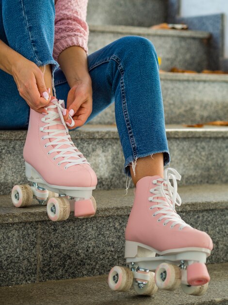 Vue côté, de, femme, sur, escalier, attacher, lacet, sur, patins a roulettes