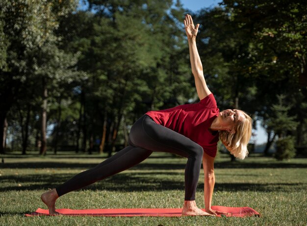 Vue côté, de, femme, exercice, position yoga, dehors