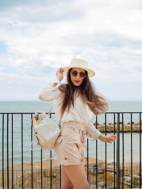 Vue côté, femme, à, lunettes soleil, et, chapeau