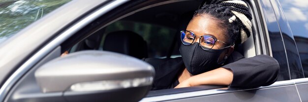 Vue côté, de, femme, à, masque visage, conduire voiture