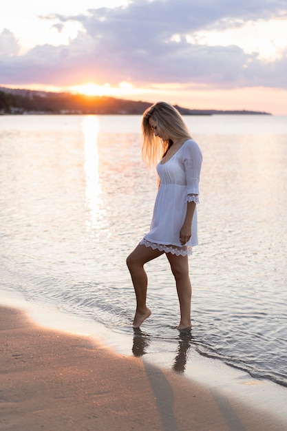 Vue côté, de, femme, plage, à, coucher soleil