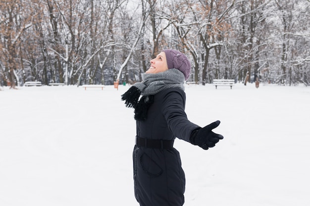 Vue de côté d&#39;une femme portant des vêtements chauds, profitant de la journée d&#39;hiver