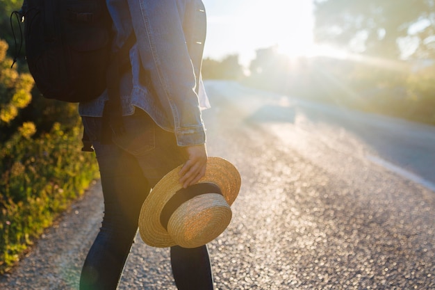 Vue côté, de, femme, à, sac à dos, route, tenue, chapeau