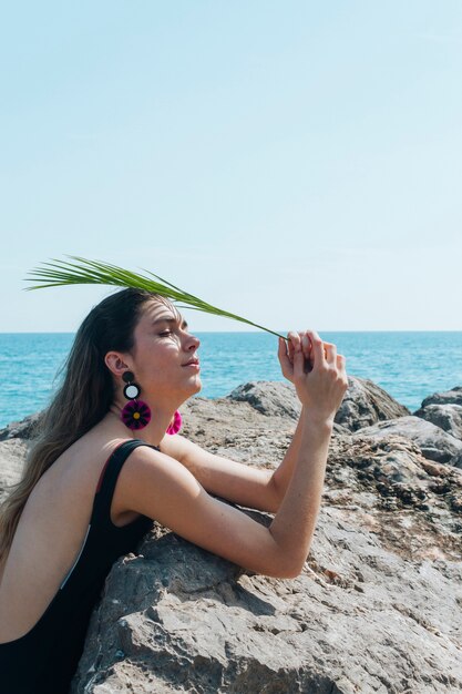 Vue côté, de, femme, tenue, paume, feuilles, dessus, tête