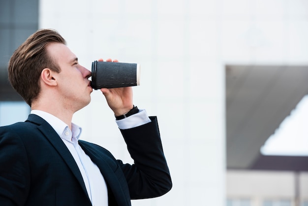 Vue de côté, homme d'affaires, boire du café