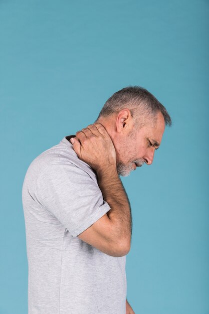 Vue de côté d&#39;un homme d&#39;âge mûr souffrant de douleurs au cou