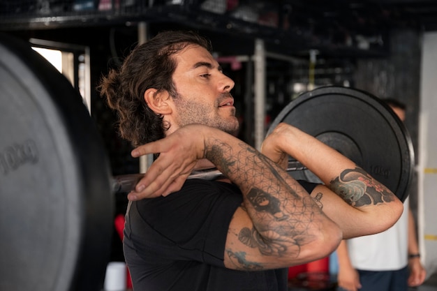 Vue de côté homme formation au gymnase