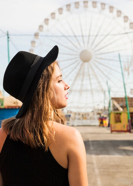 Photo gratuite vue de côté de la jeune femme dans un parc d'attractions