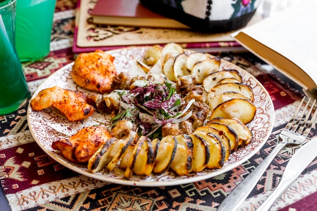Photo gratuite vue de côté kebab pomme de terre hachée avec grosse queue avec brochette de poulet et oignons
