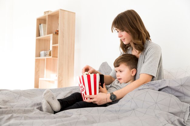 Vue côté, maman fils, manger, pop-corn