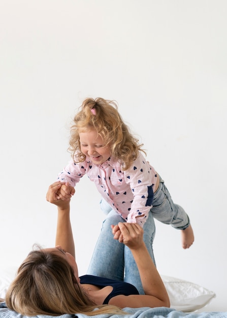 Photo gratuite vue côté mère jouant avec une fille heureuse