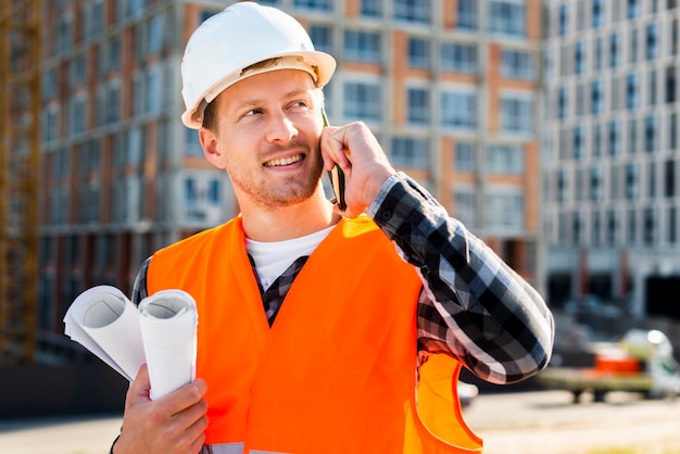 Vue de côté moyen d&#39;ingénieur parlant au téléphone