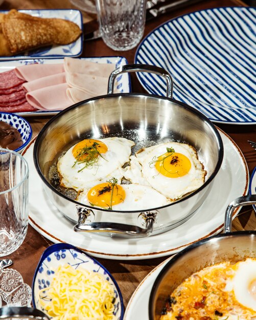 Vue côté, de, oeufs frits, dans, a, casserole, sur, table bois