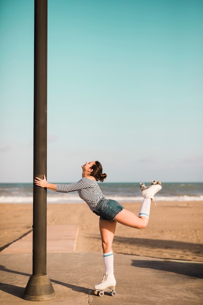 Vue côté, de, a, patineur, tenue, pilier, debout, devant, plage