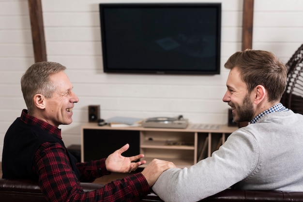 Photo gratuite vue côté, de, père fils, reposer ensemble, sur, sofa