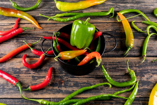 Vue de côté poivron et piment dans une poêle noire