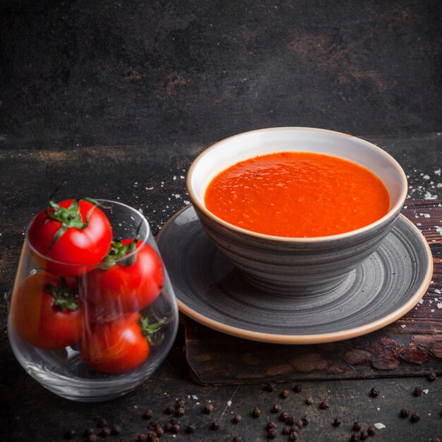 Vue de côté soupe aux tomates avec des tomates en plaque