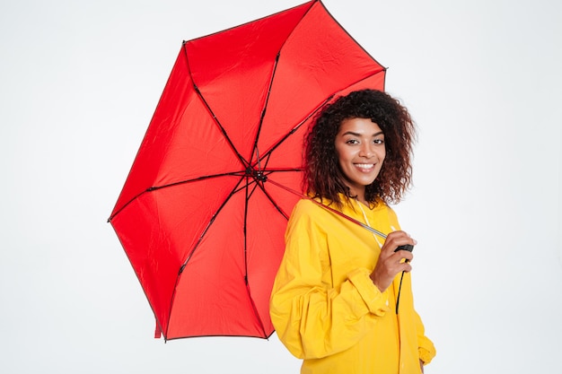 Vue côté, de, sourire, femme africaine, dans, imperméable, poser