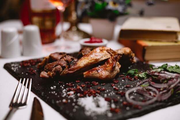 Vue de côté steak avec épine-vinette et oignons sur un plateau