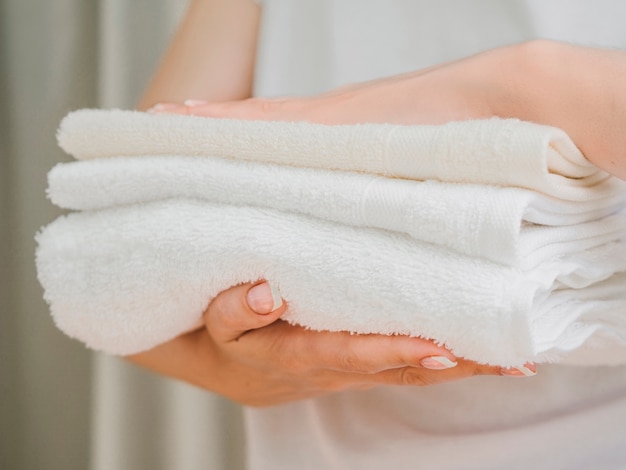 Vue de côté tas de serviettes entre les mains