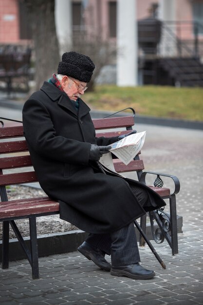 Vue de côté vieil homme lisant le journal