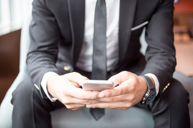 Vue croisée de Business Man Texting sur Smartphone