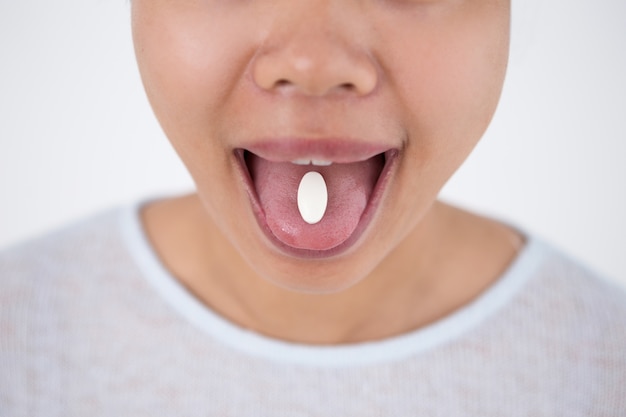 Photo gratuite vue croisée de la pilule de maintien de la femme sur la langue