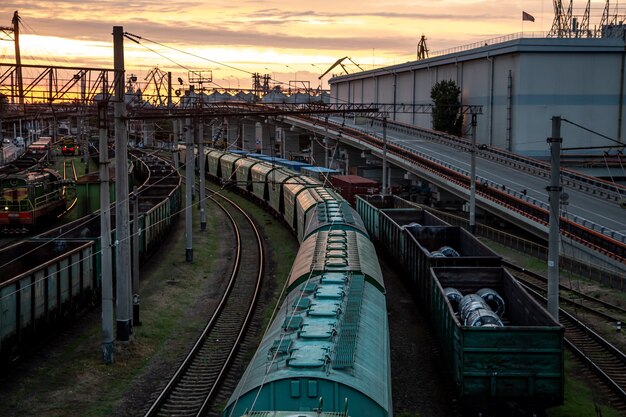 Vue depuis le pont de chemin de fer vers les trains de marchandises au coucher du soleil.