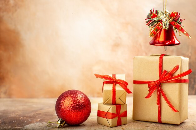 Vue de dessous cadeaux de Noël en ruban de papier brun jouets d'arbre de Noël sur papier journal sur fond beige