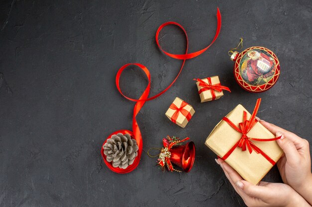 Vue de dessous cadeaux de Noël en ruban de papier brun jouets d'arbre de Noël sur papier journal sur fond beige