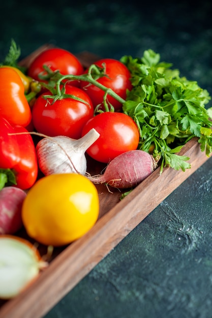 Vue de dessous des légumes frais sur planche de bois dans l'obscurité