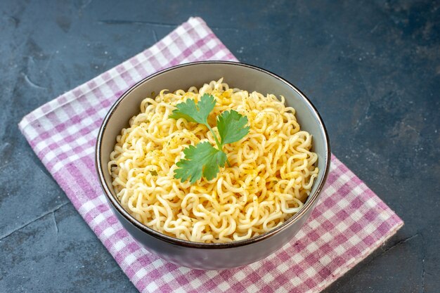 Vue de dessous des nouilles ramen dans un bol sur une serviette sur une table sombre