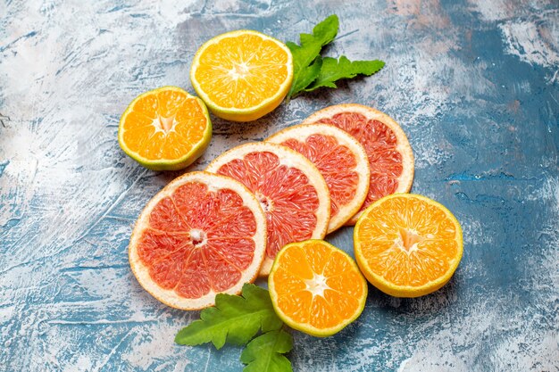 Vue de dessous des oranges et des pamplemousses coupés sur une surface blanche bleue