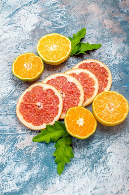 Vue de dessous des oranges et des pamplemousses coupés sur une surface blanche bleue