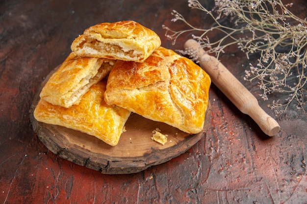 Vue de dessous penovani khachapuri sur un rouleau à pâtisserie en bois sur une table rouge foncé