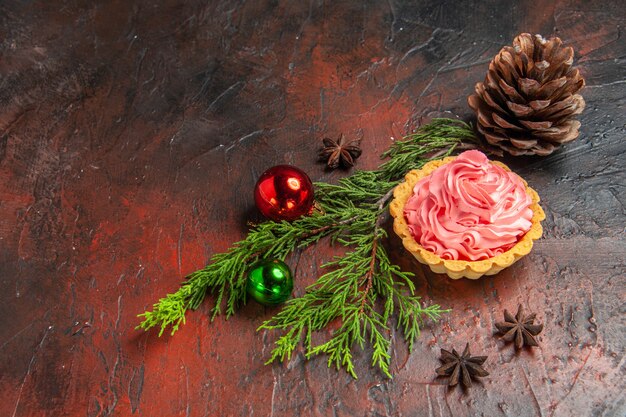 Vue de dessous petite étoile acidulée anis arbre de Noël jouets pomme de pin sur table rouge foncé avec espace libre