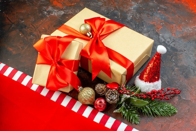 Photo gratuite vue de dessous petits cadeaux bonnet de noel tasse de thé sur fond rouge foncé