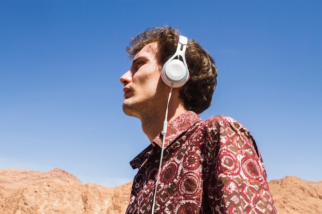 Vue de dessous portrait d&#39;homme écoutant de la musique dans le désert