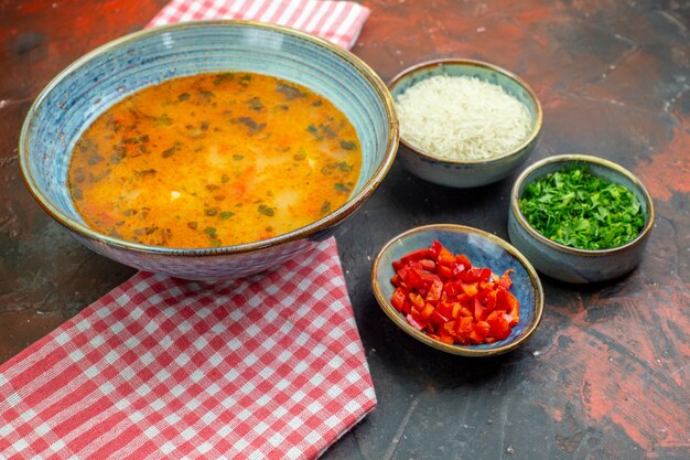 Vue de dessous soupe de riz dans un bol sur une nappe à carreaux rouge blanc d'autres trucs dans des bols sur la table