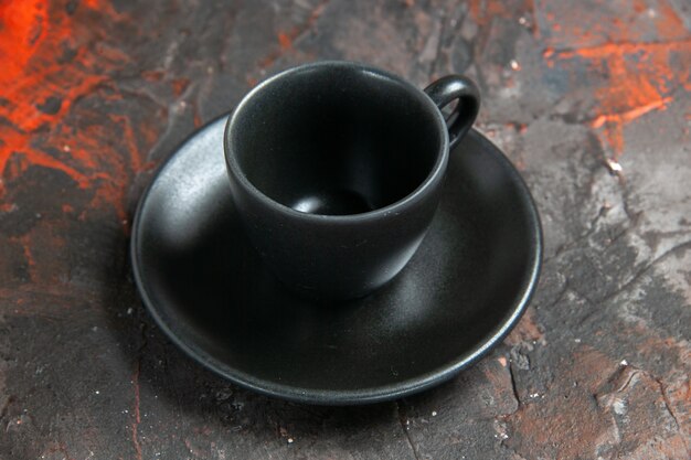 Vue de dessous tasse et soucoupe noires sur table sombre