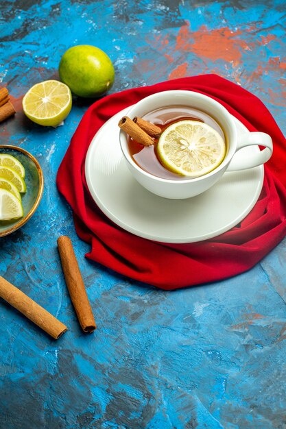 Vue de dessous tasse de thé avec châle rouge citron et cannelle sur une surface rouge bleu