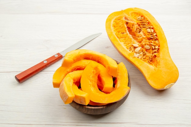 Vue de dessous tranches de courge musquée dans des bols demi-couteau à courge sur table grise