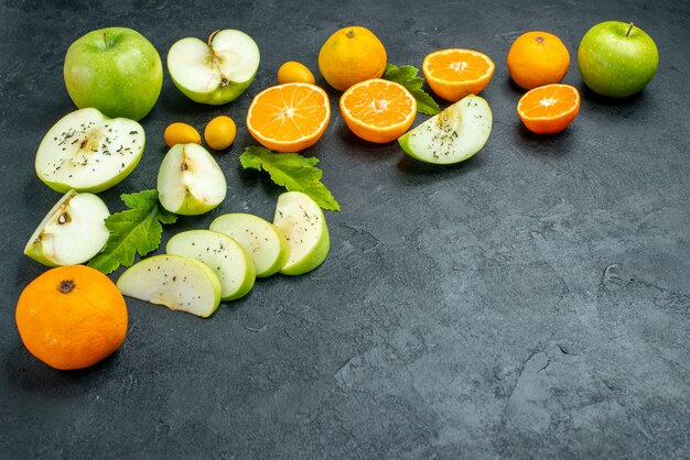 Vue de dessous des tranches de pomme mandarine laisse du cumcuat sur un espace libre de table sombre