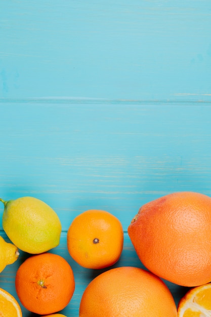 Vue de dessus des agrumes comme le citron orange et la mandarine sur fond bleu avec copie espace