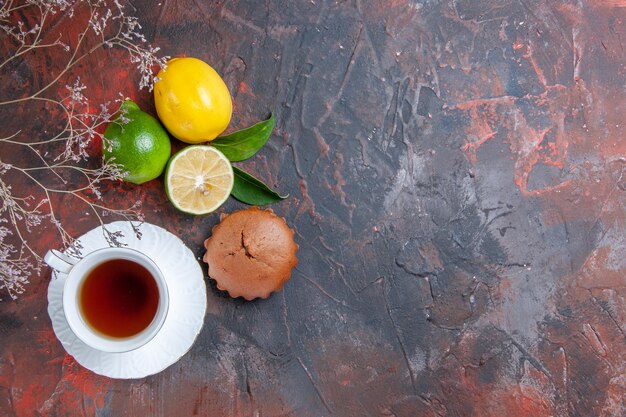 Vue de dessus des agrumes une tasse de thé branches d'arbres cupcake citron lime