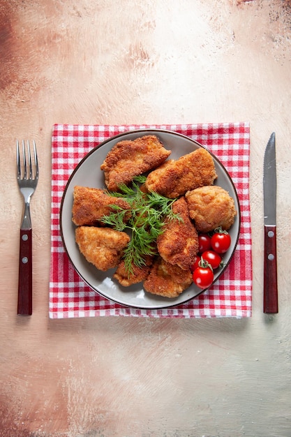 Vue de dessus des ailes de poulet savoureuses avec des légumes verts et des tomates sur fond clair dîner viande nourriture déjeuner frites burger repas