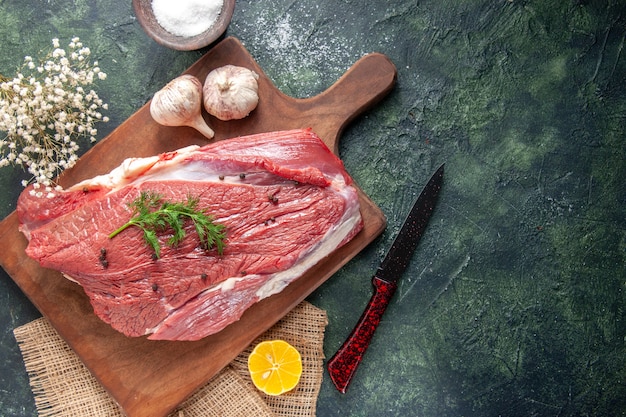 Vue de dessus d'ails de viande rouge crue fraîche sur une planche à découper en bois Citron sur une serviette de couleur nude Farine de couteau à fleur sur fond de couleur mélangée