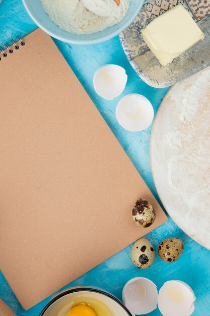 Vue de dessus des aliments sous forme d'oeuf et de beurre avec coquille d'oeuf sur fond bleu avec copie espace