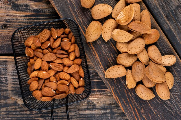 Vue de dessus des amandes dans un panier noir sur une table en bois foncé. horizontal