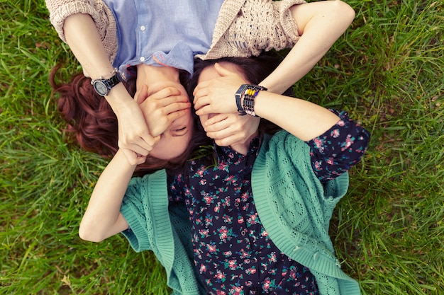 Vue de dessus d'amis souriants allongé sur l'herbe s'amuser